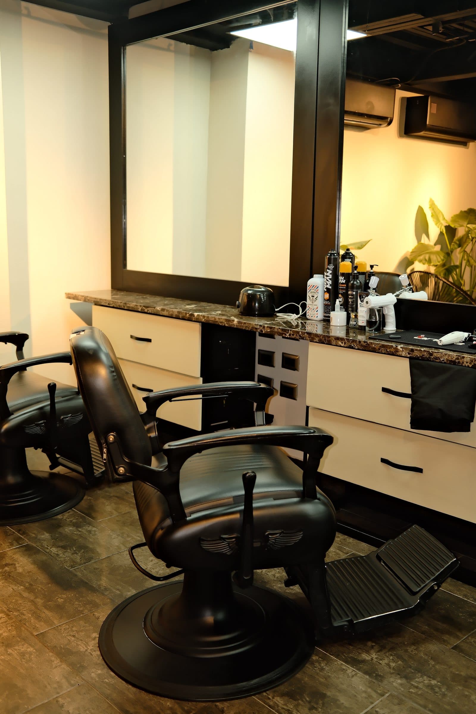 Silla de barbero frente al espejo y el mueble de trabajo de la barbería