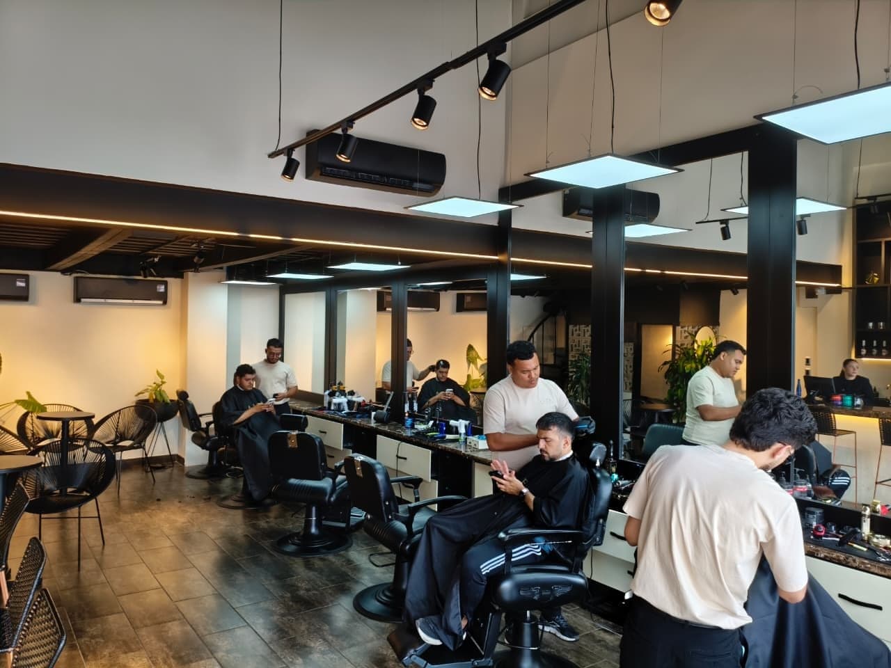 Barberos atendiendo a varios clientes a la vez en el salón de ALFA en Barranquilla