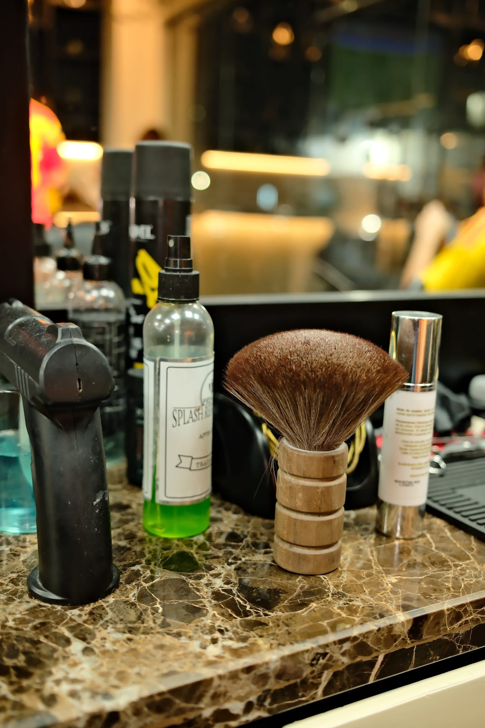 Brocha de barbero y productos de afeitado sobre el mármol del puesto de trabajo